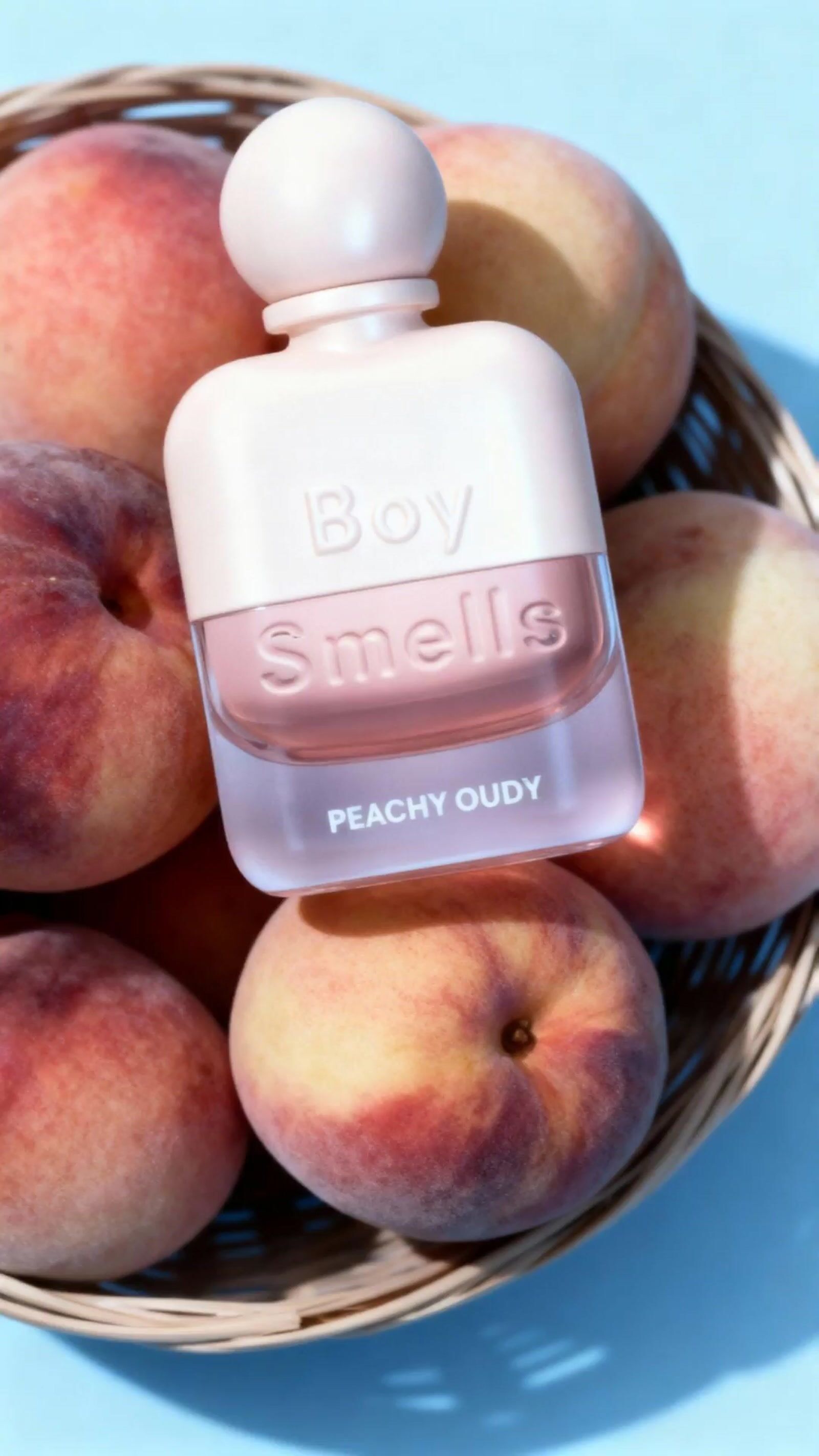 a basket filled with peaches and a bottle of perfume