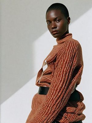 a woman standing in front of a white wall