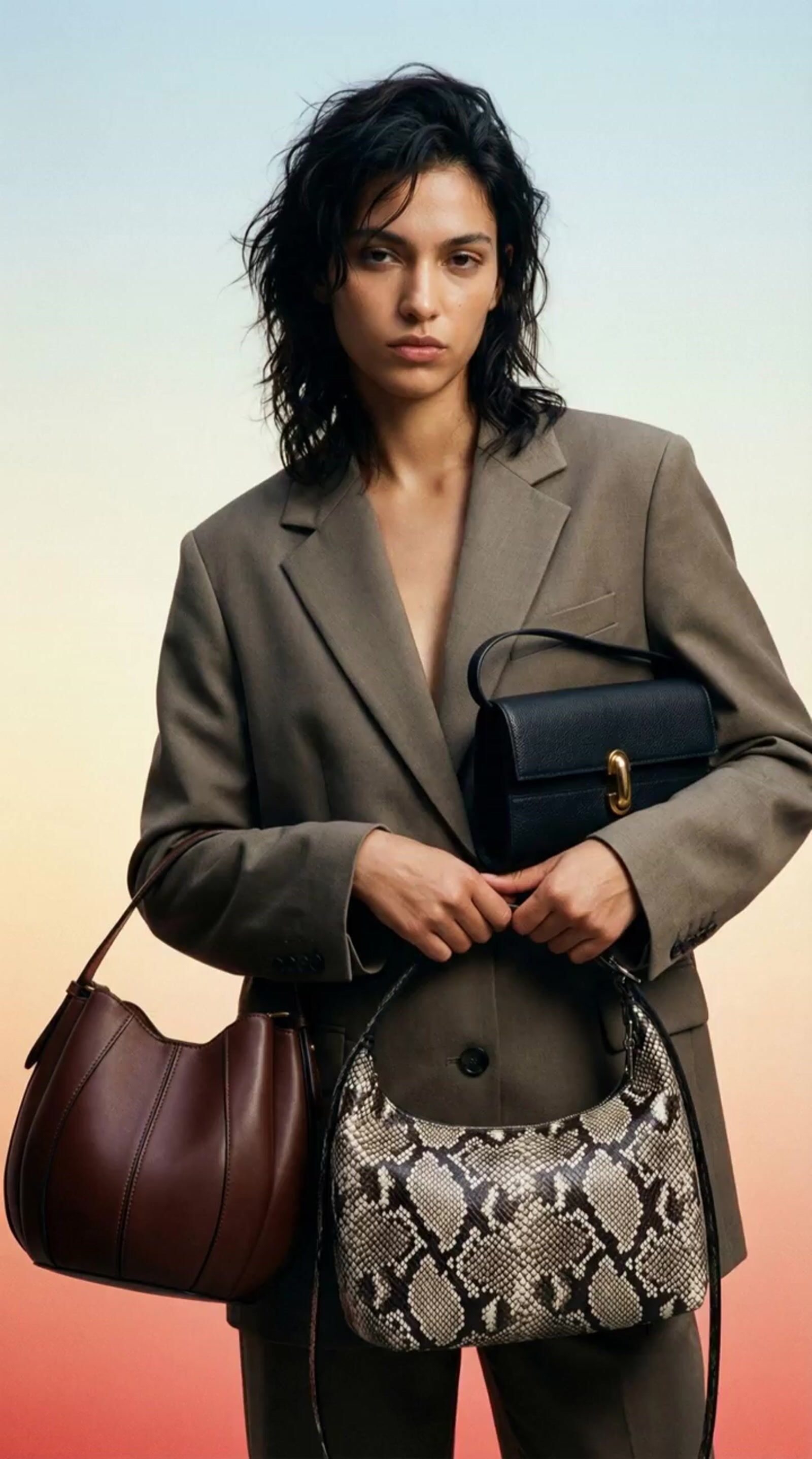 a woman in a suit holding a purse