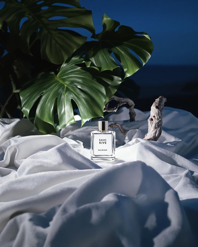 a bottle of perfume sitting on top of a white sheet