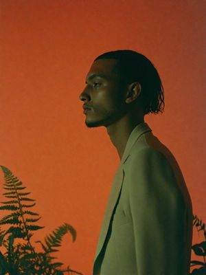 a man standing in front of an orange background