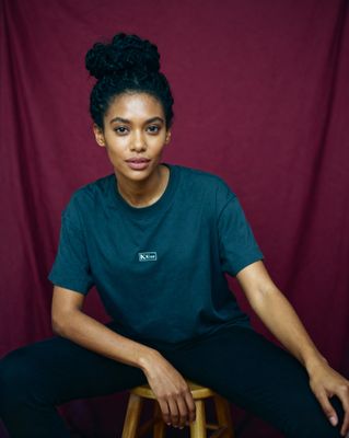 a woman sitting on top of a wooden stool