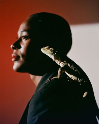 a man holding a small lizard on his arm