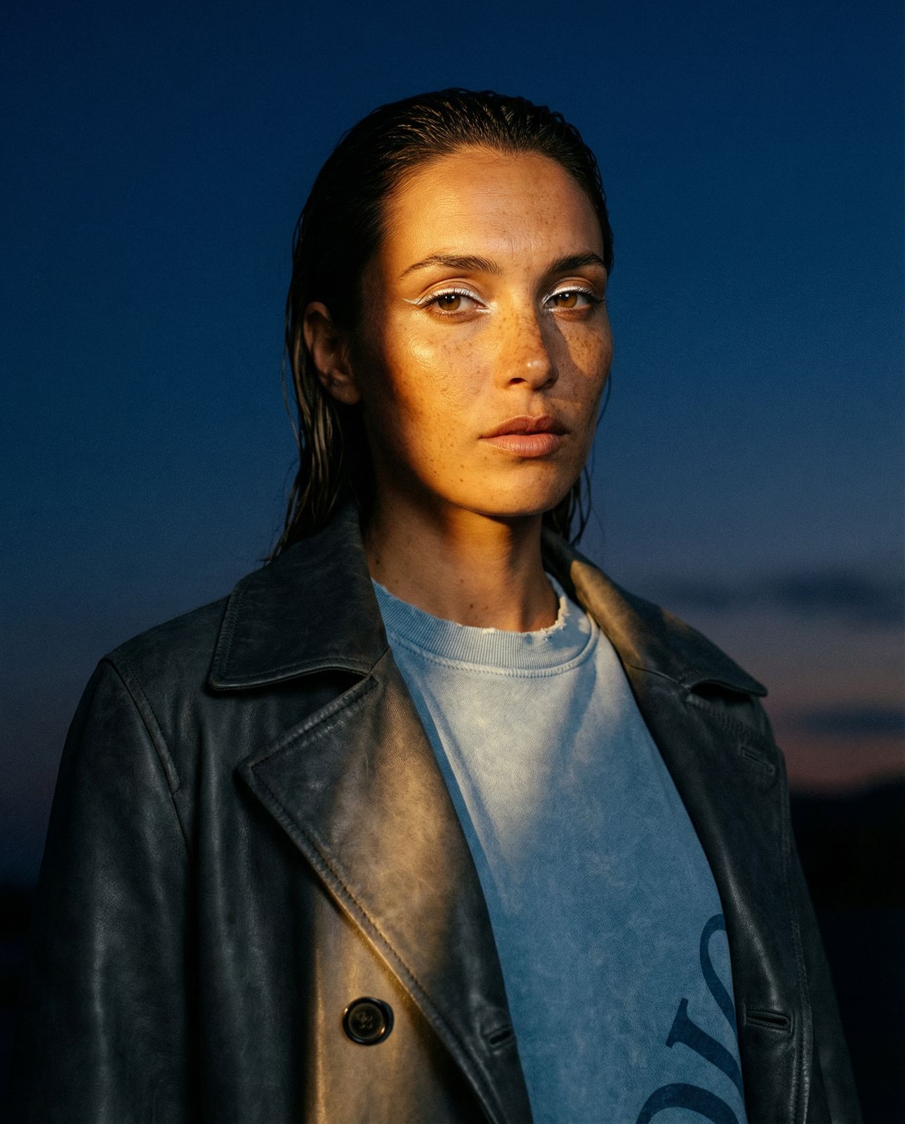 a woman wearing a leather jacket and a blue shirt