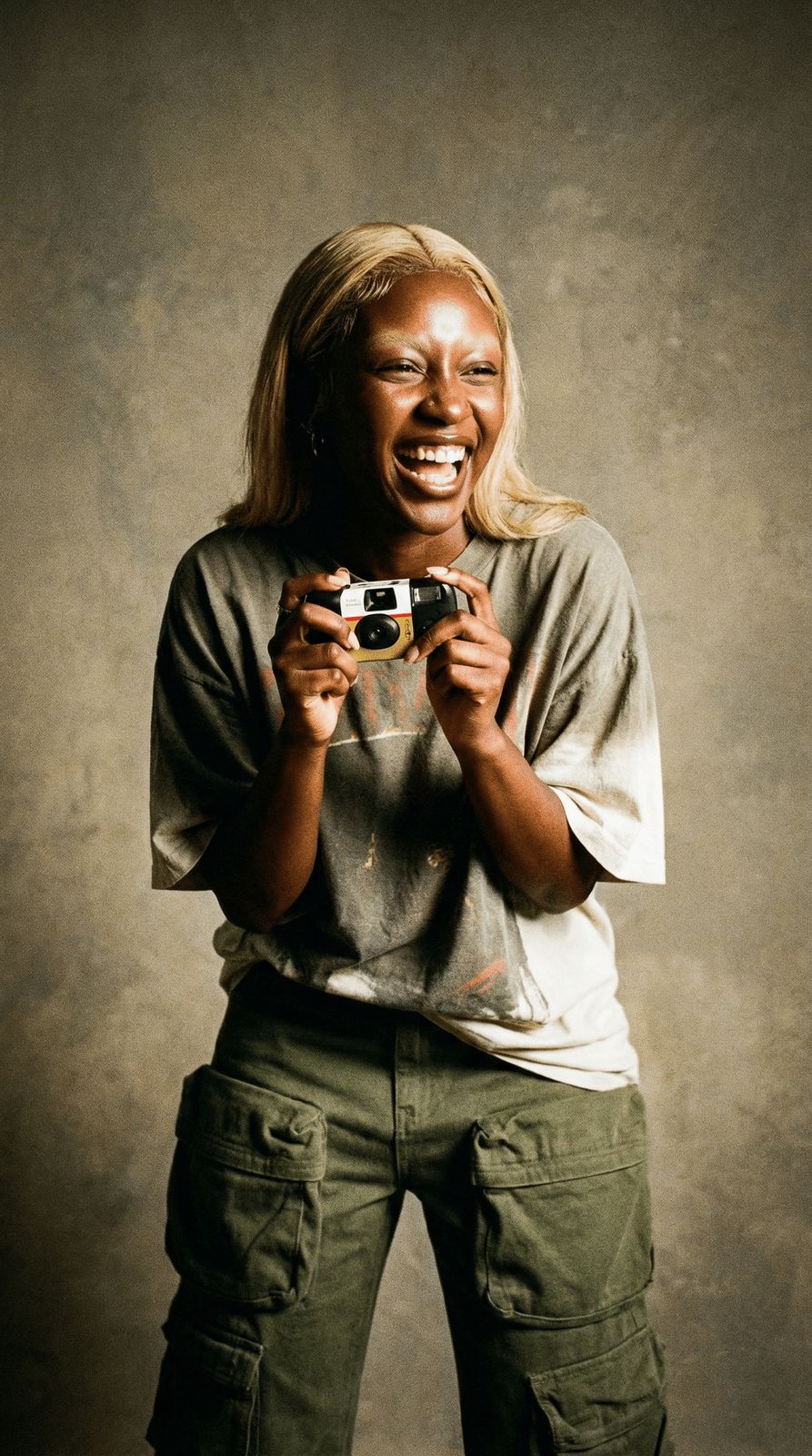 a woman is holding a camera and smiling