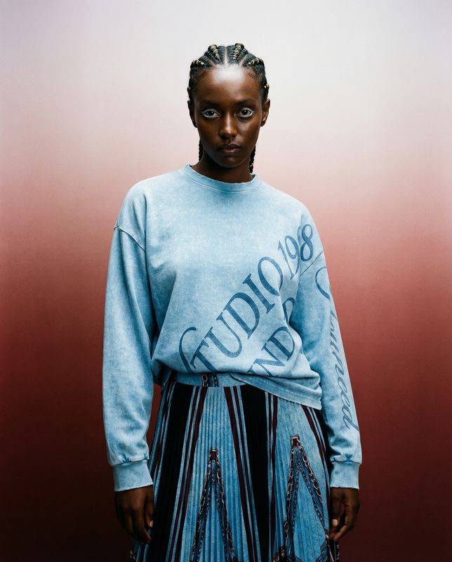 a woman with braids wearing a blue sweater