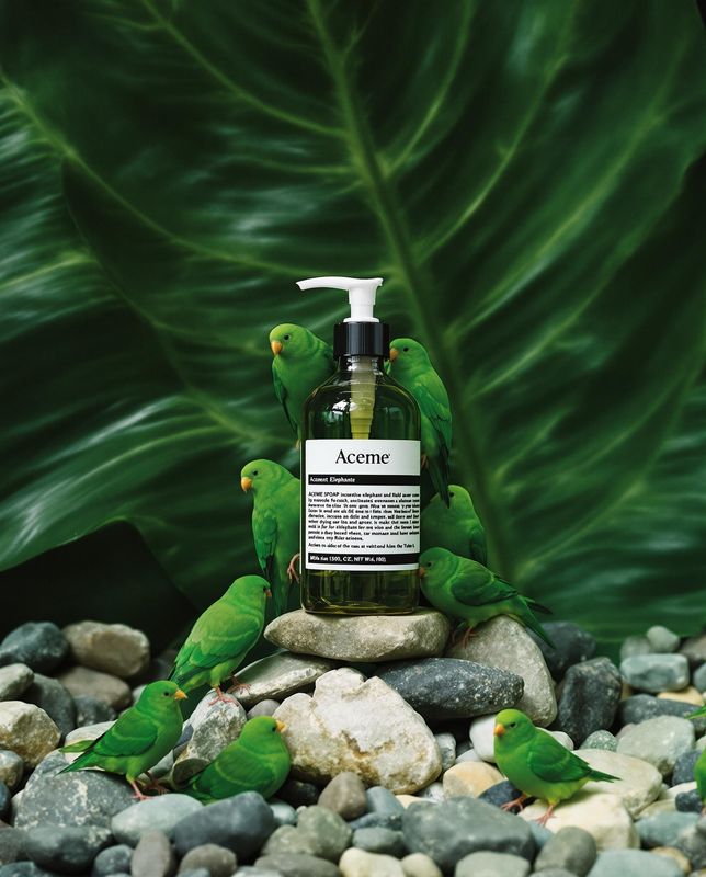 a bottle of soap sitting on top of a pile of rocks