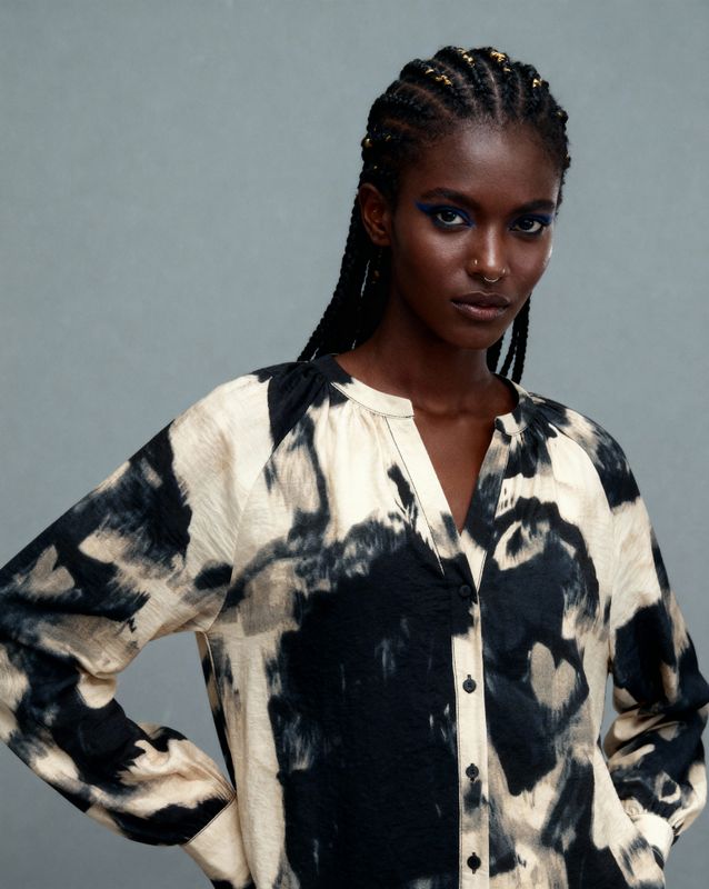 a woman with braids wearing a black and white shirt