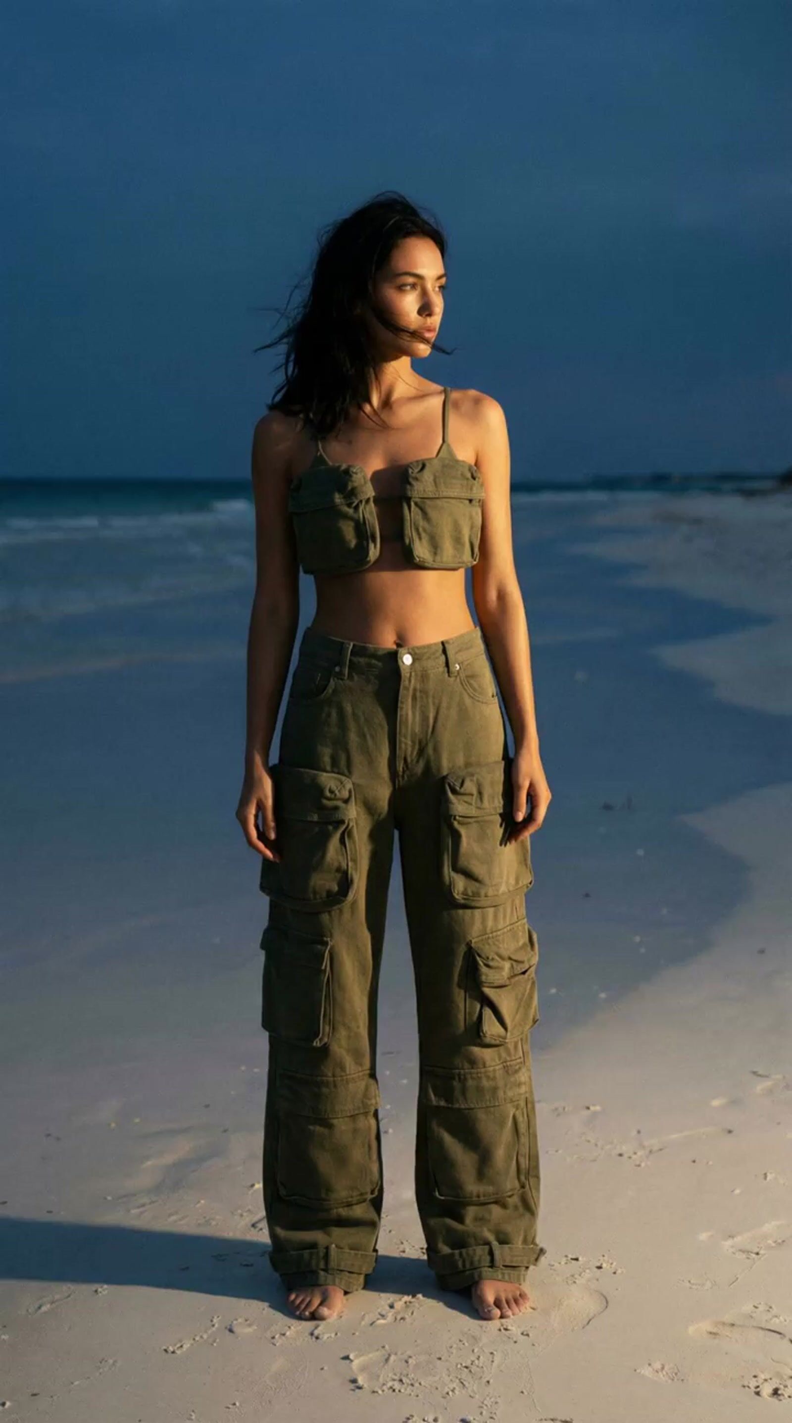 a woman standing on top of a sandy beach