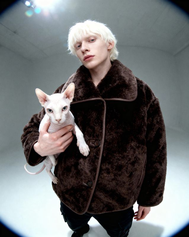 a man holding a white cat in his arms