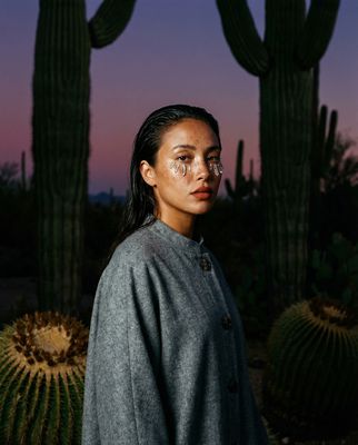a woman standing in front of a cactus