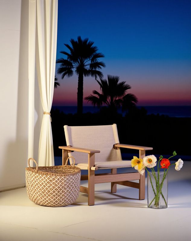 a chair sitting next to a vase with flowers in it