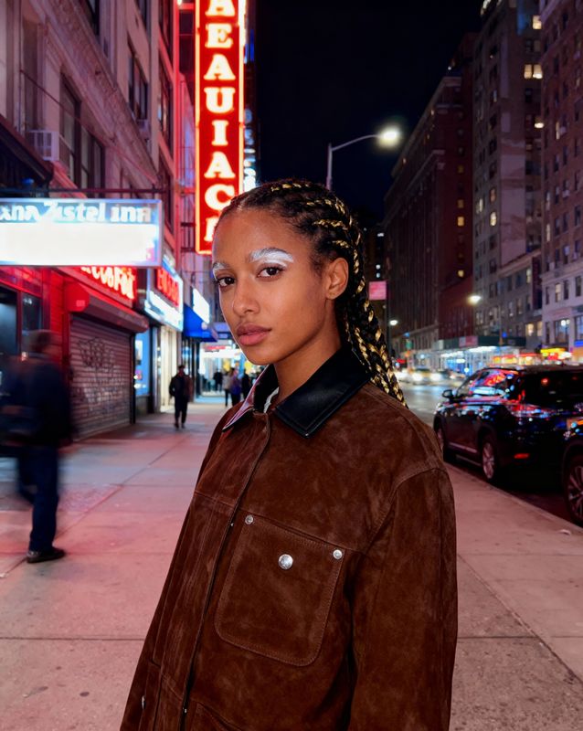 a woman with braids standing on a city street