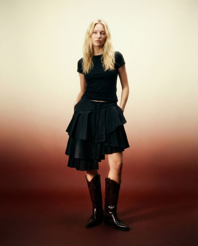 a woman in a black dress and boots