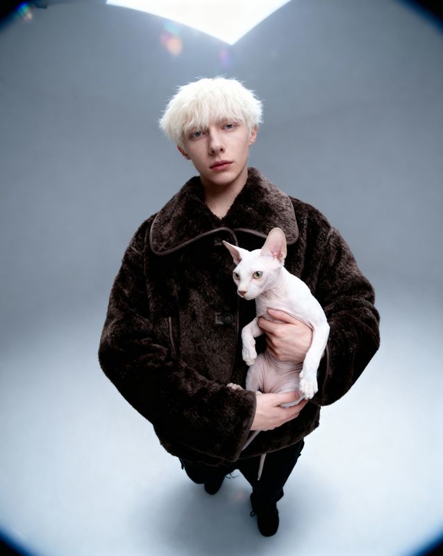 a man holding a white cat in his arms