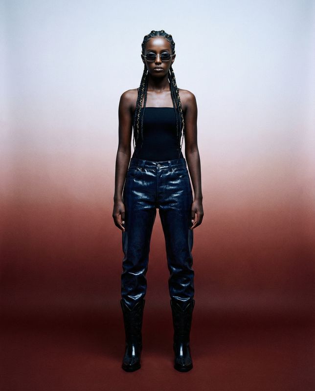 a woman with braids standing in front of a red and white background