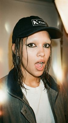 a woman with a hat on her head making a funny face