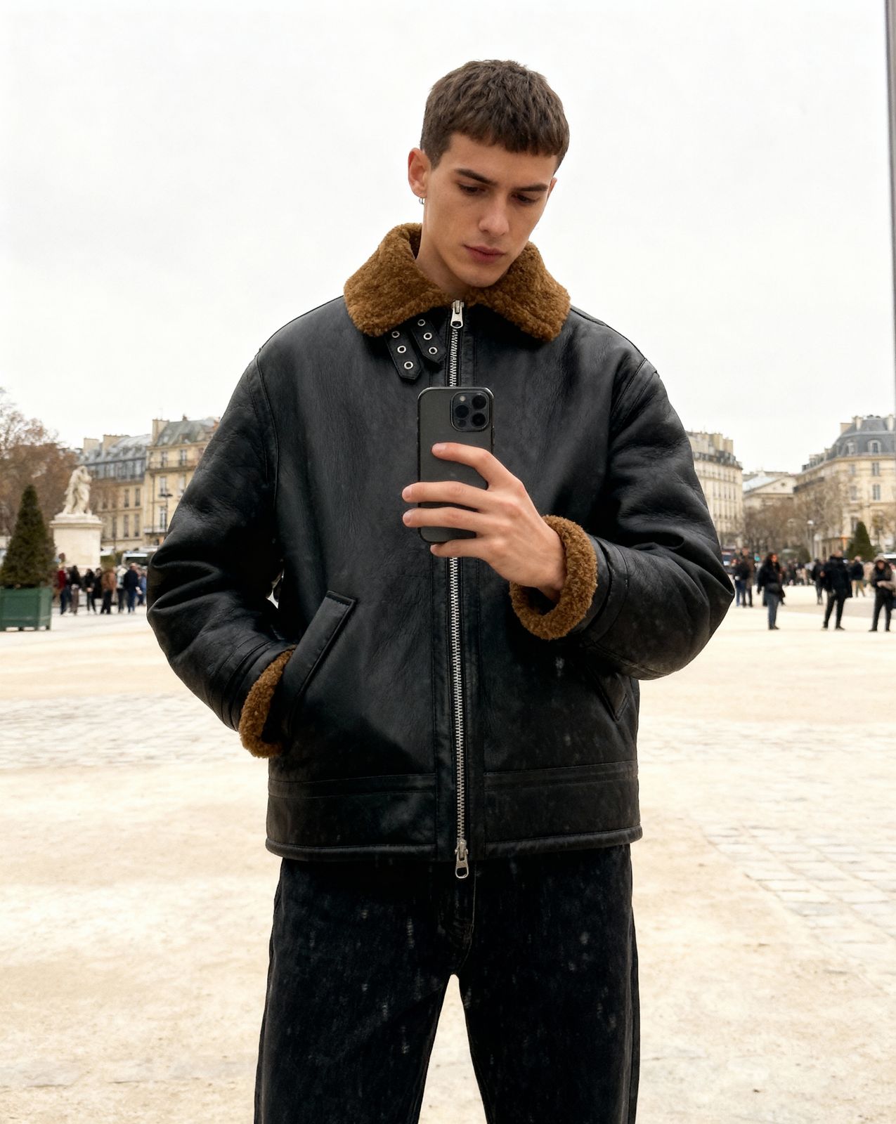 a man in a black jacket looking at his cell phone