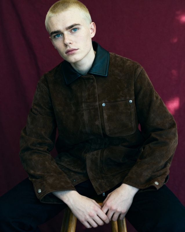 a man sitting on top of a wooden stool
