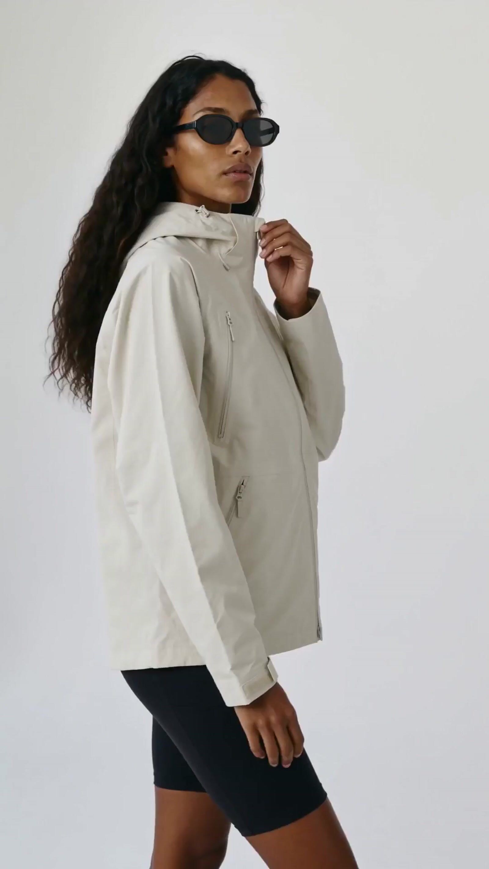 a woman wearing a white jacket and black shorts