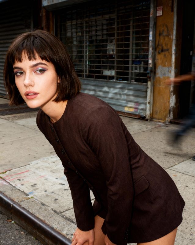 a woman leaning on a rail on a city street