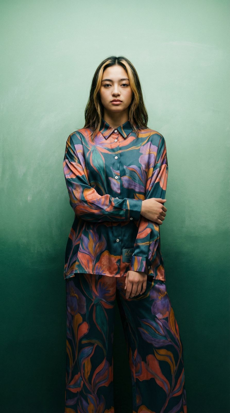 a woman standing in front of a green wall