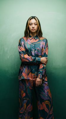 a woman standing in front of a green wall