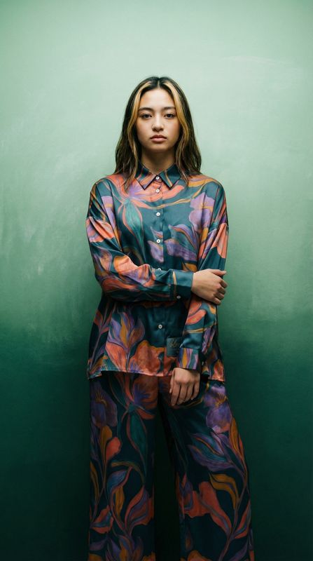 a woman standing in front of a green wall