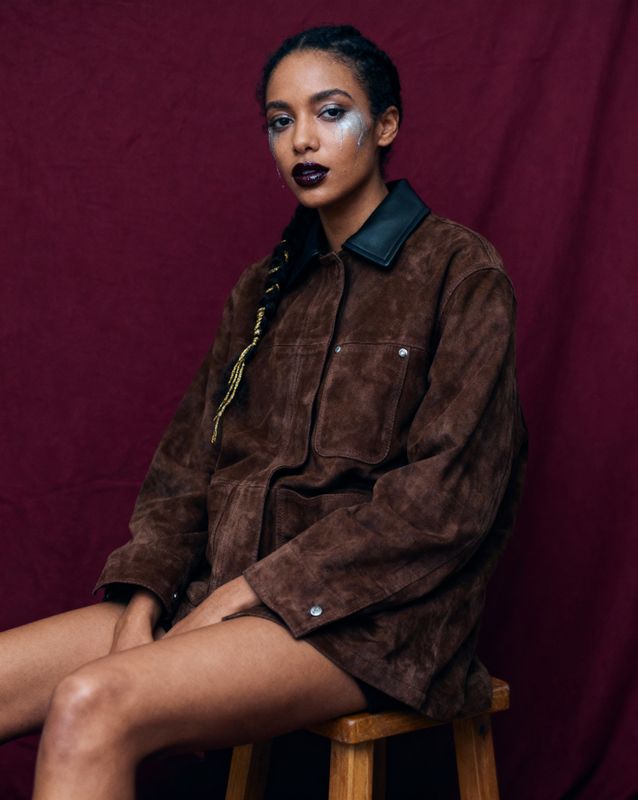 a woman sitting on top of a wooden stool