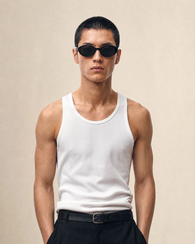 a man in a white tank top and black pants