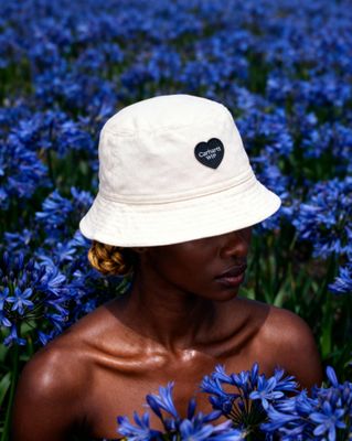 a woman wearing a white hat in a field of blue flowers