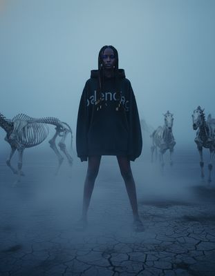 a woman standing in front of a group of skeletons