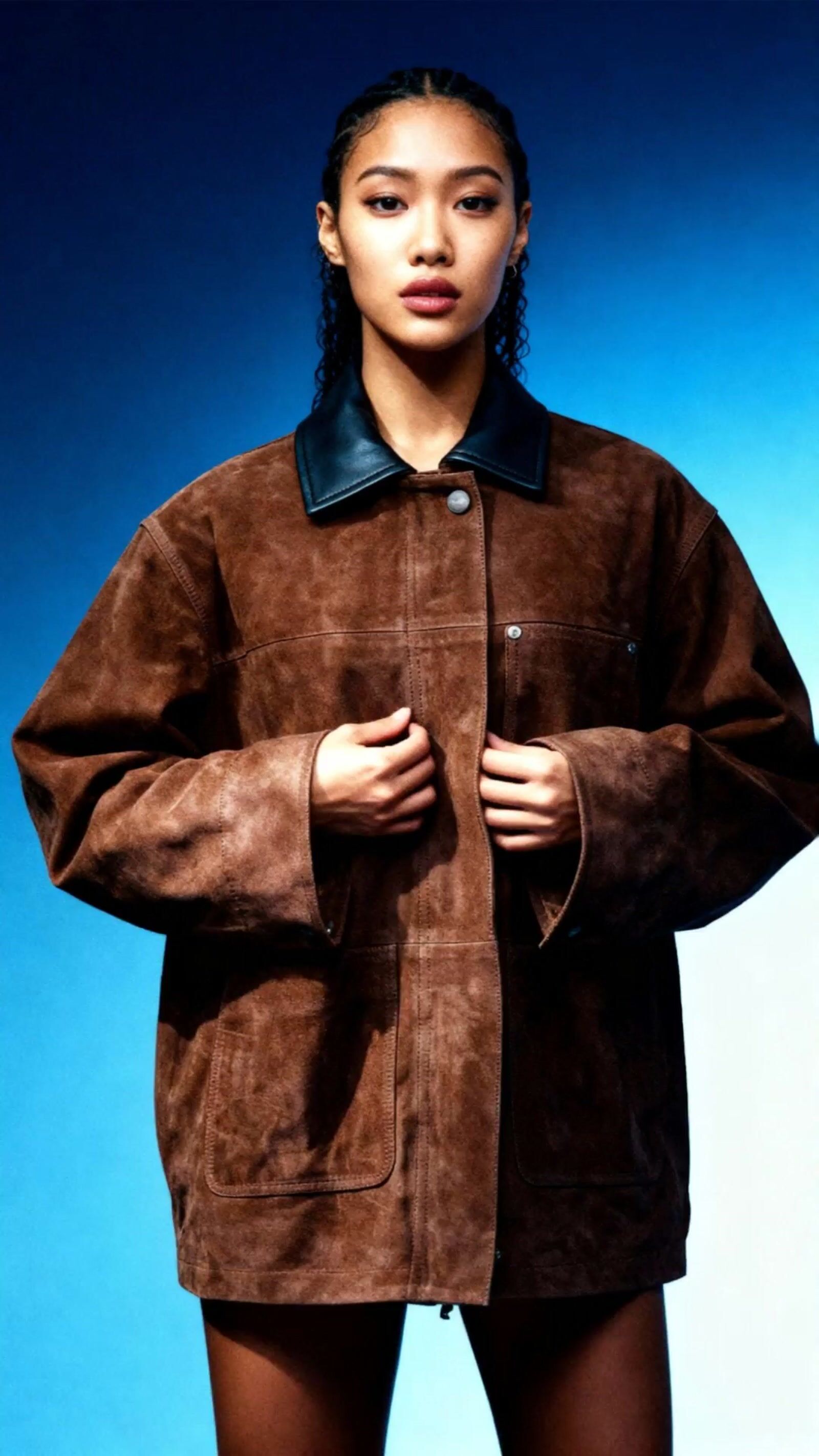 a woman wearing a brown jacket and black shorts
