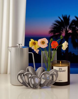 a table with a candle, vase, and flowers on it
