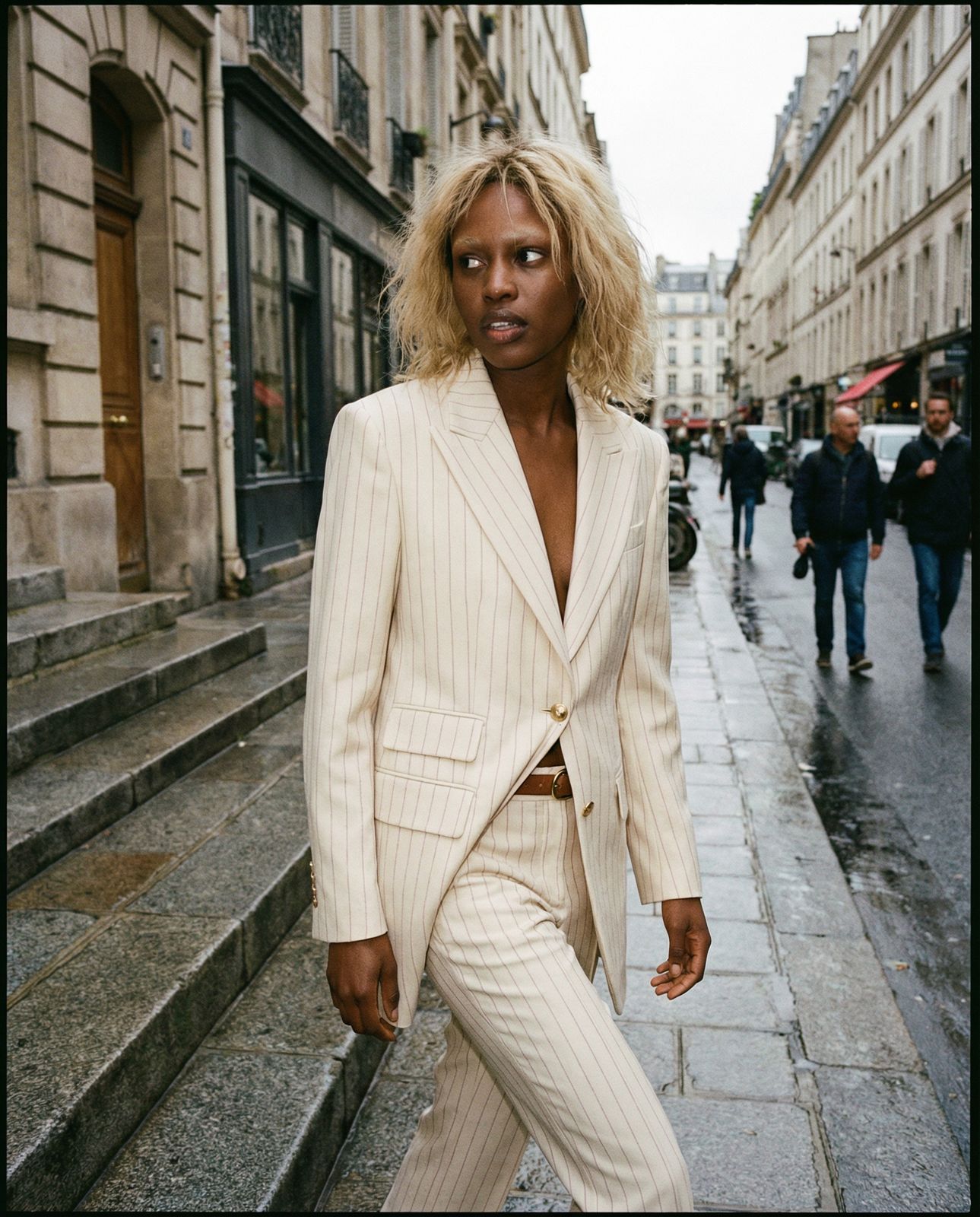 a woman in a suit walking down a street