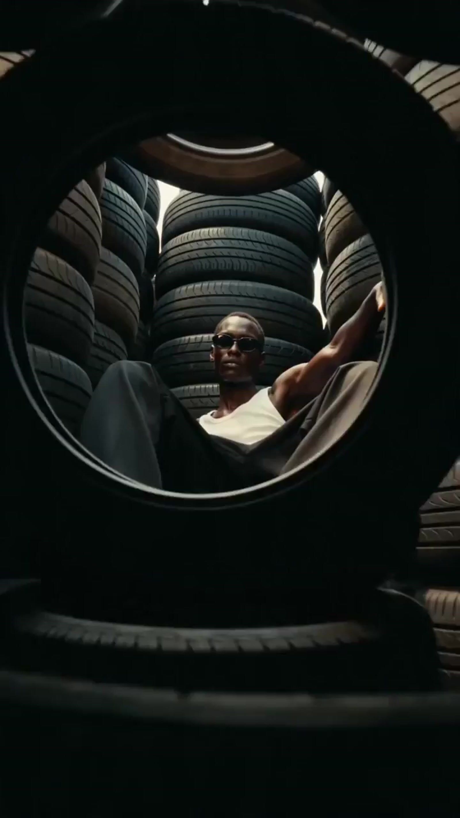 a man sitting in the back of a truck filled with tires