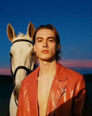 a man standing next to a white horse