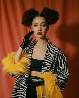 a woman in a zebra print jacket and black gloves