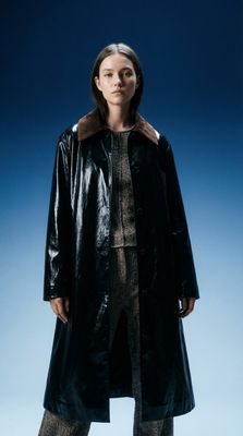 a woman wearing a black coat and pants