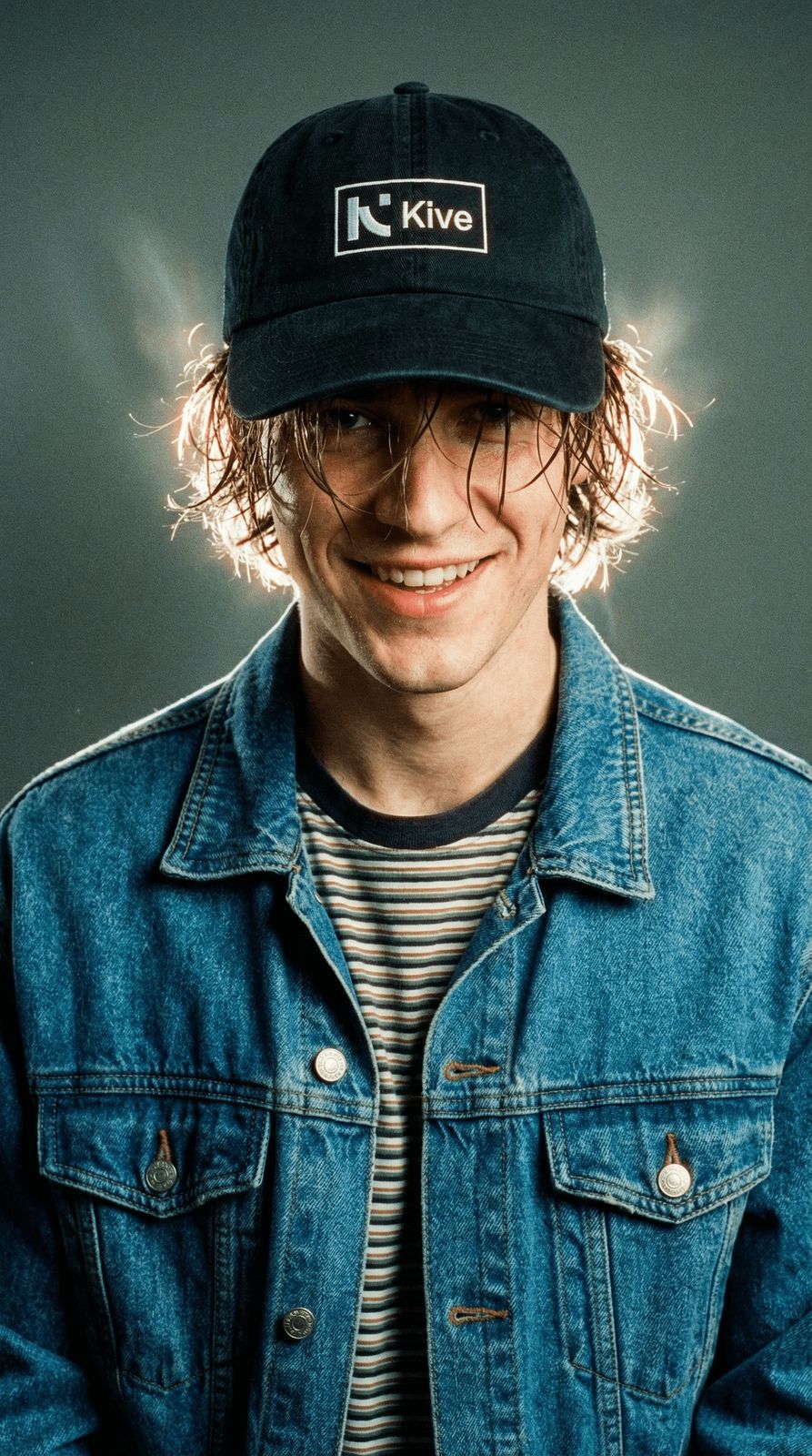 a man wearing a hat and a denim jacket