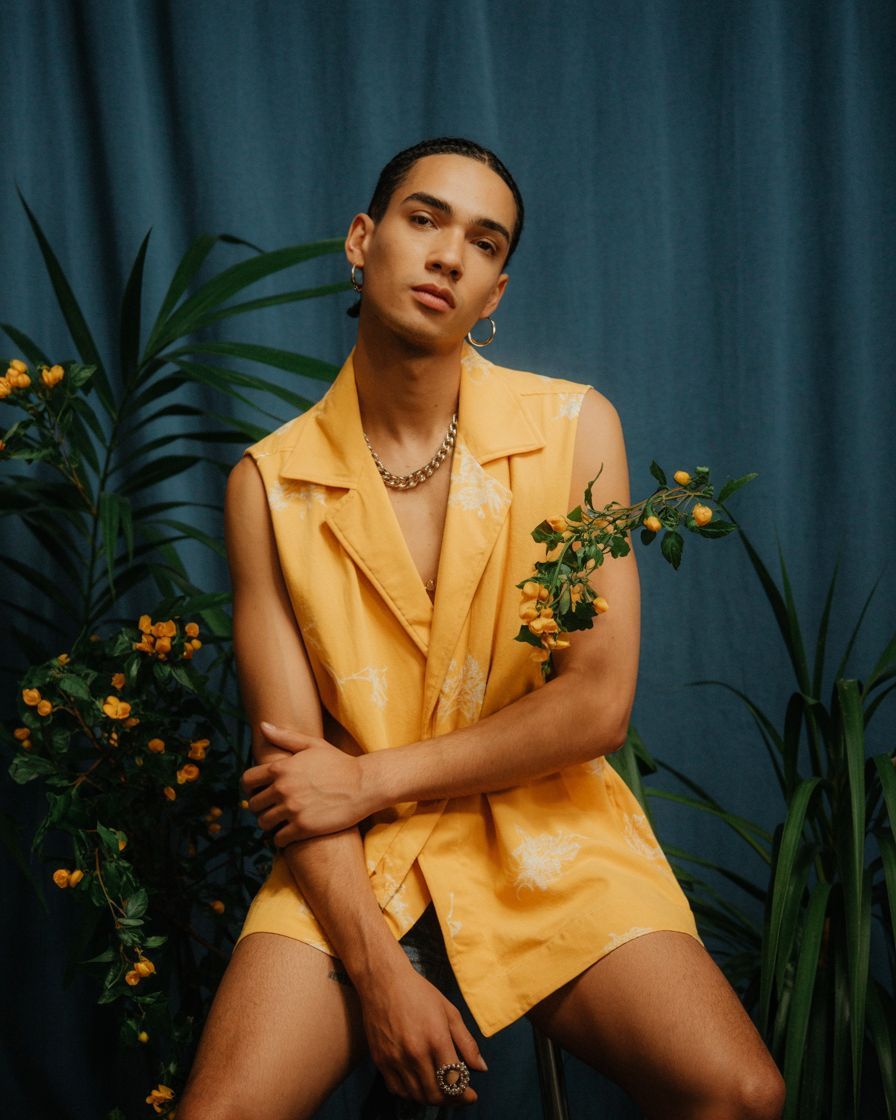 a man sitting on a chair in front of a plant