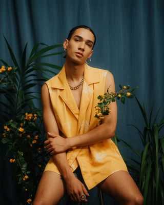 a man sitting on a chair in front of a plant