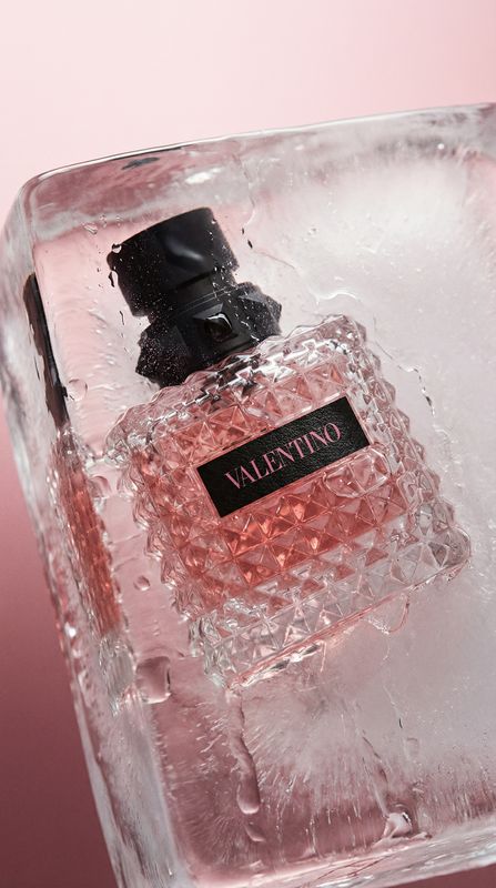 a bottle of perfume sitting on top of ice