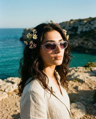 a woman wearing sunglasses and a flower in her hair