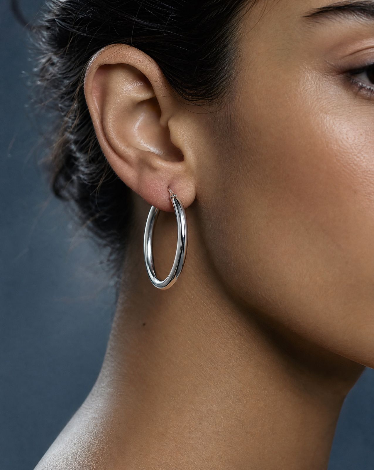 a close up of a person wearing a pair of earrings