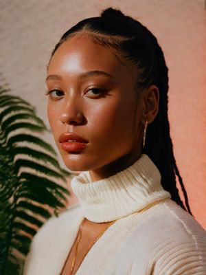 a woman wearing a white turtle neck sweater