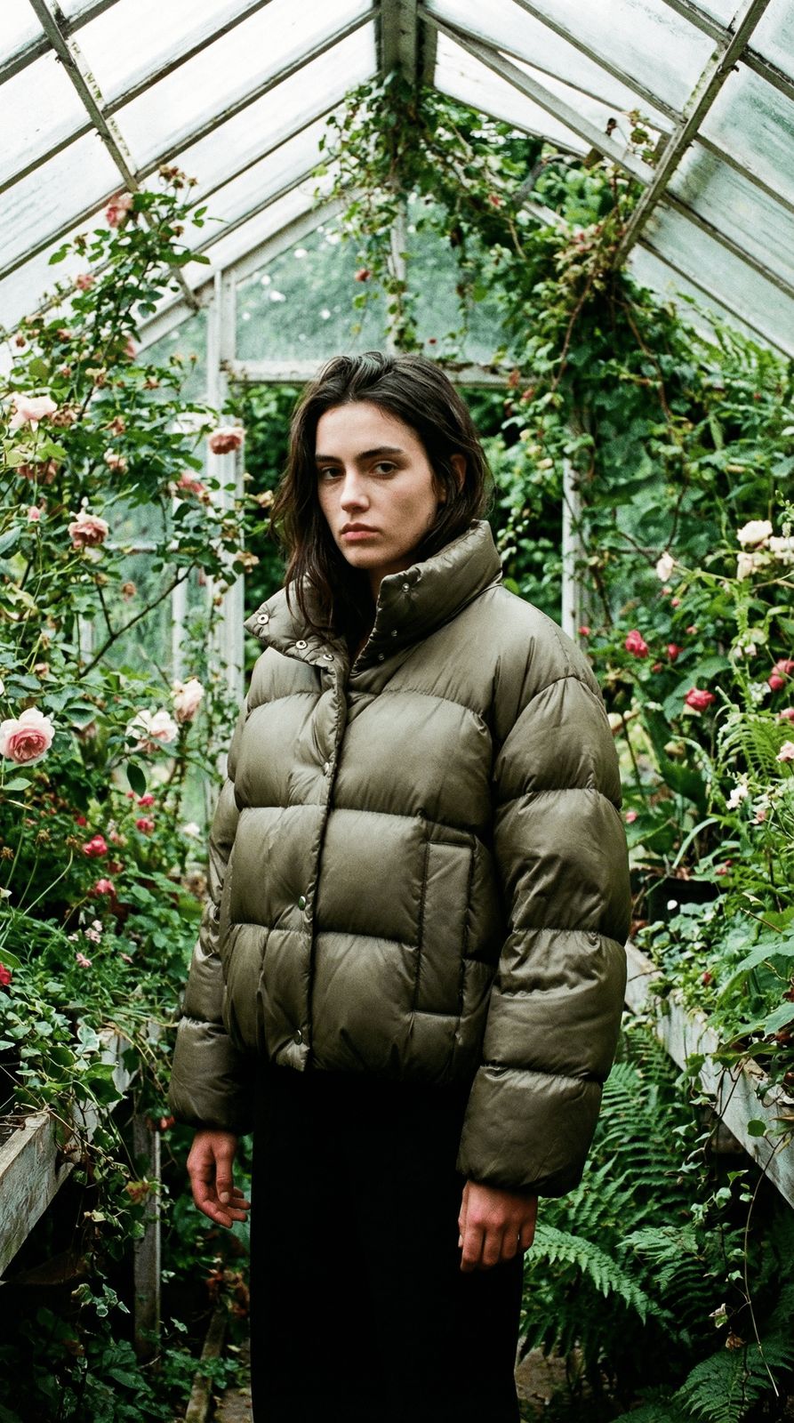 a woman standing in front of a greenhouse