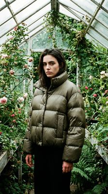 a woman standing in front of a greenhouse