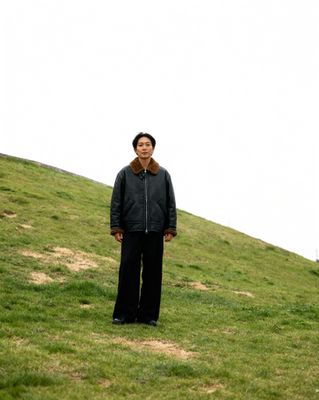 a man standing on top of a lush green hillside