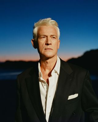 a man in a black suit and white shirt